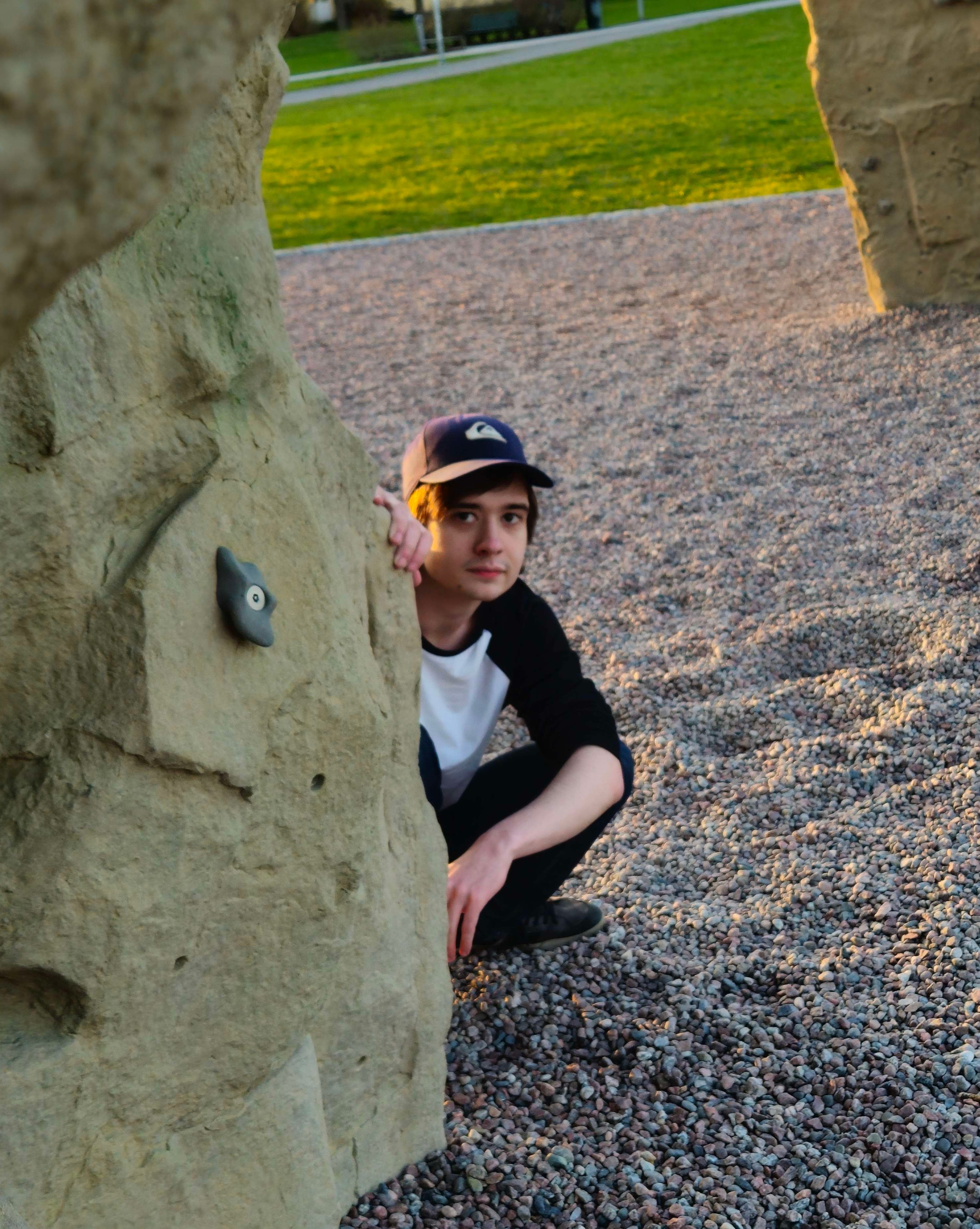 Me squatting next to a climbing rock